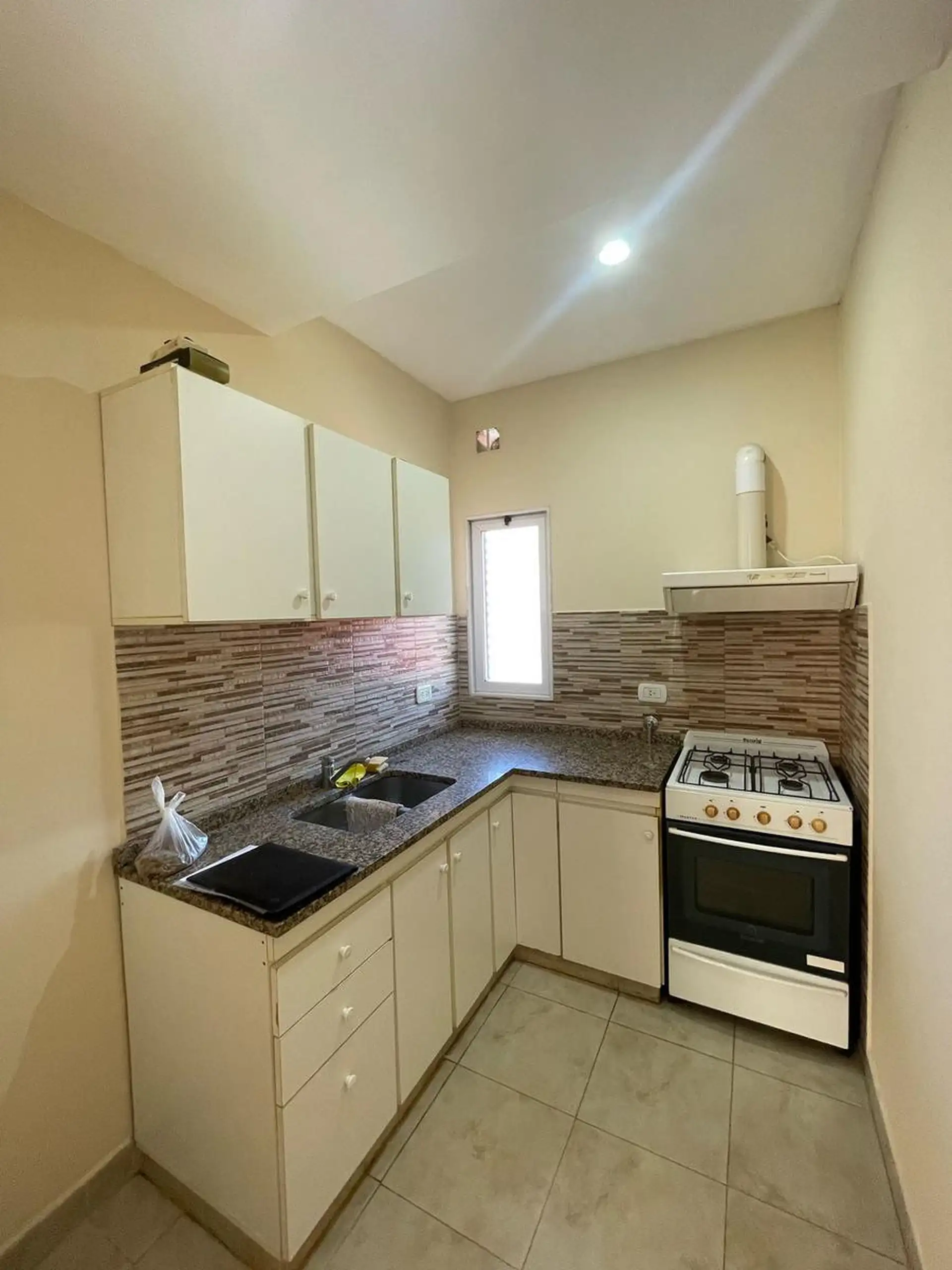 Apartamento tipo kitnet com pequeno pátio em unidade térrea